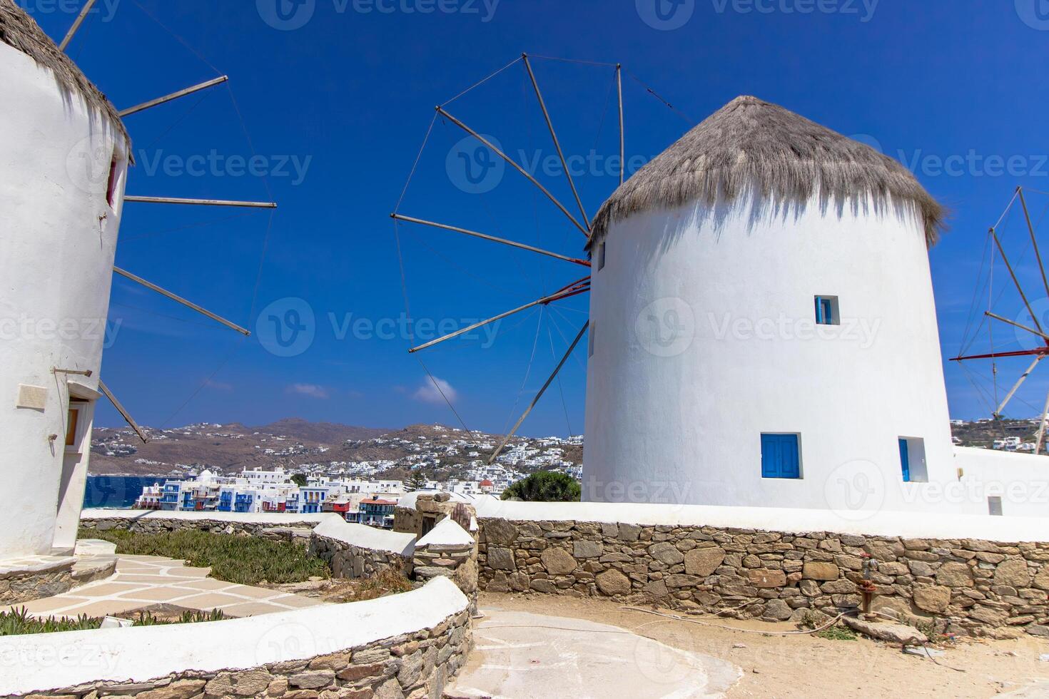 Traditional Greek windmills on Mykonos island under cloudy sky. Aerial view of iconic Mykonos windmills in Cyclades, Greece. photo