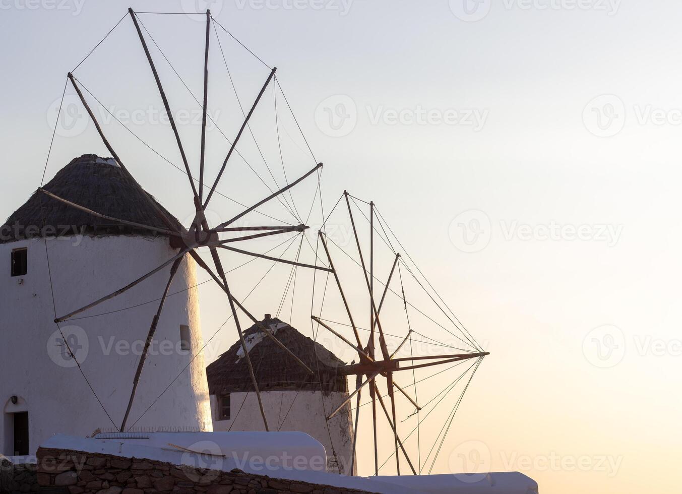 Traditional Greek windmills on Mykonos island under cloudy sky. Aerial view of iconic Mykonos windmills in Cyclades, Greece. photo