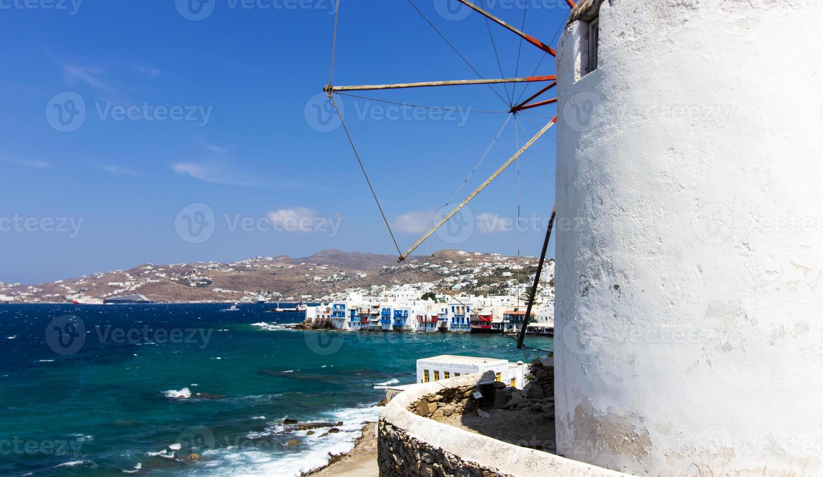 Traditional Greek windmills on Mykonos island under cloudy sky. Aerial view of iconic Mykonos windmills in Cyclades, Greece. photo