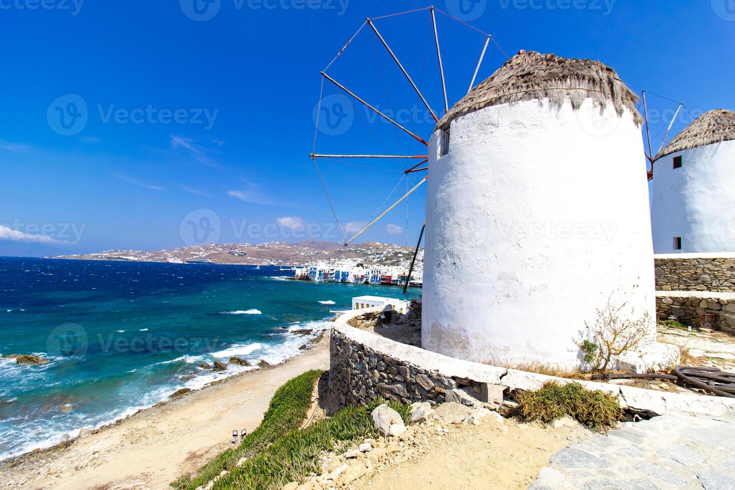 Traditional Greek windmills on Mykonos island under cloudy sky. Aerial view of iconic Mykonos windmills in Cyclades, Greece. photo
