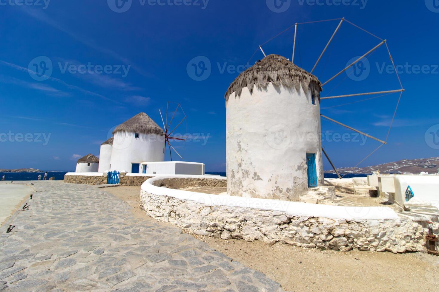 Traditional Greek windmills on Mykonos island under cloudy sky. Aerial view of iconic Mykonos windmills in Cyclades, Greece. photo