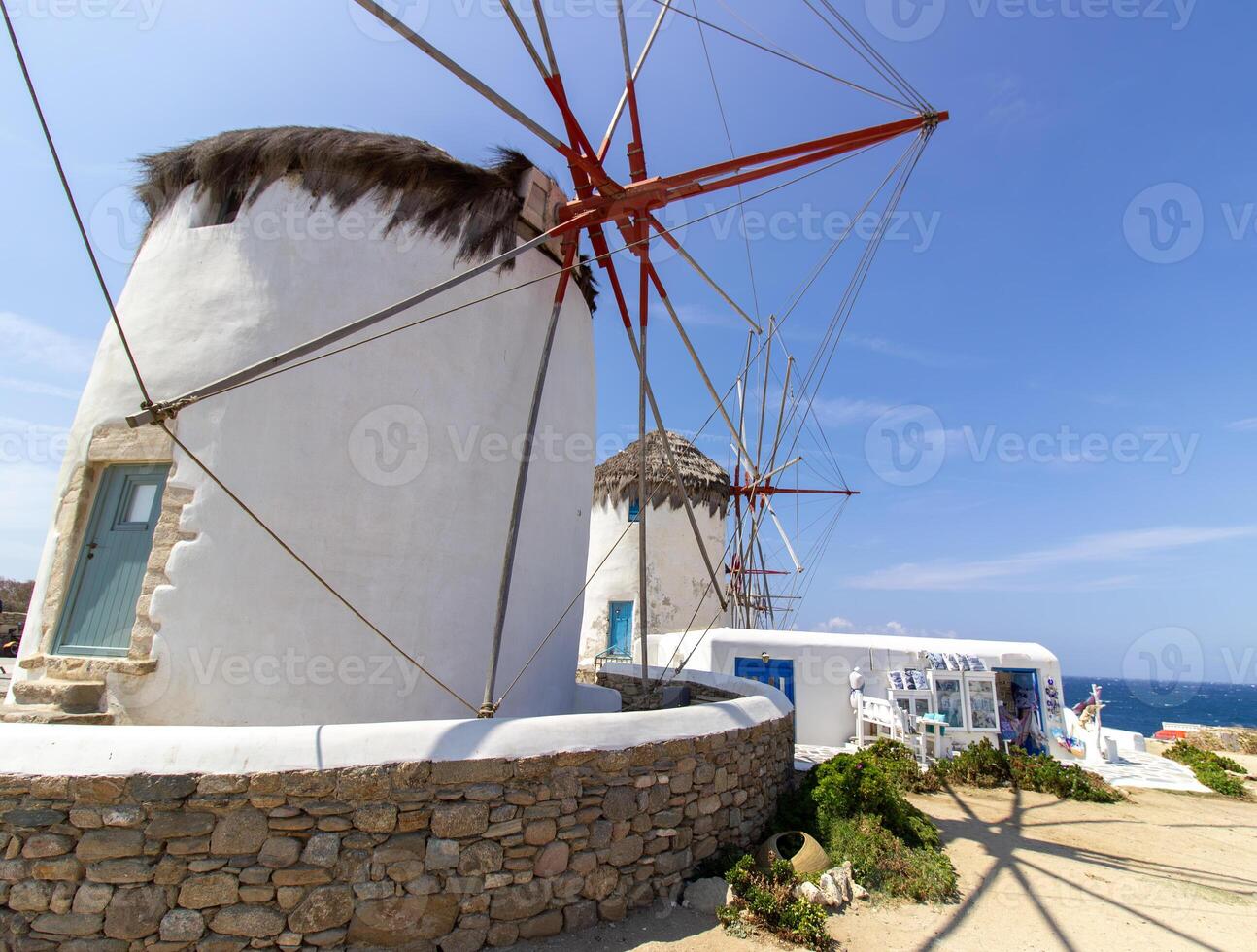 Traditional Greek windmills on Mykonos island under cloudy sky. Aerial view of iconic Mykonos windmills in Cyclades, Greece. photo