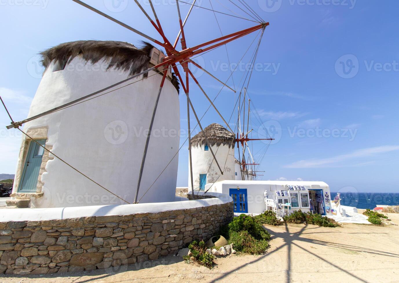 Traditional Greek windmills on Mykonos island under cloudy sky. Aerial view of iconic Mykonos windmills in Cyclades, Greece. photo