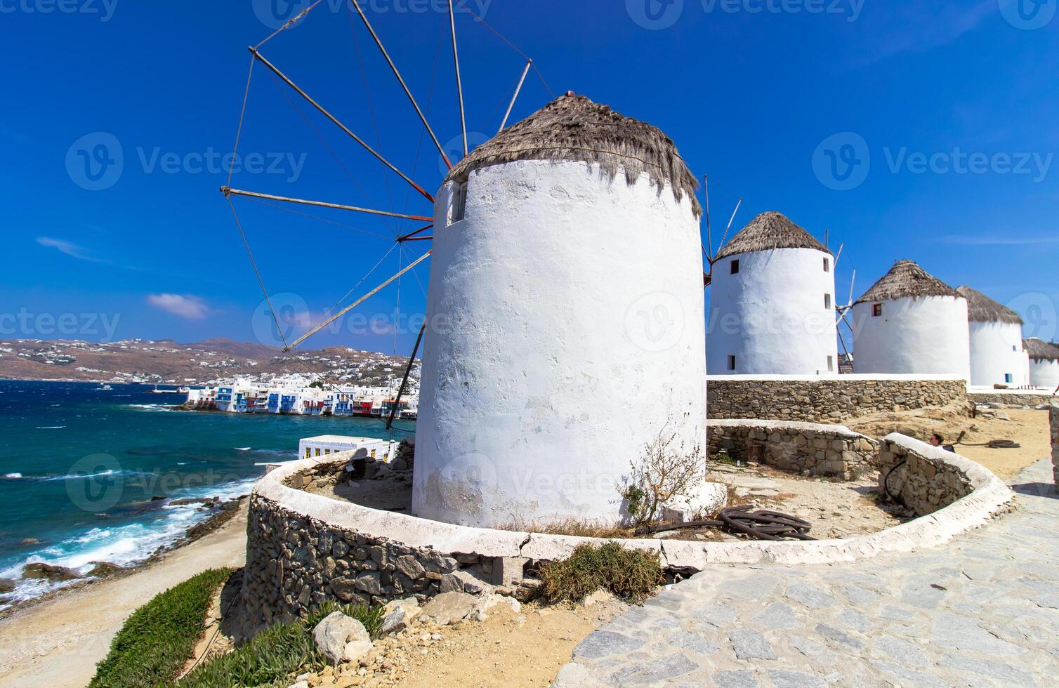 Traditional Greek windmills on Mykonos island under cloudy sky. Aerial view of iconic Mykonos windmills in Cyclades, Greece. photo