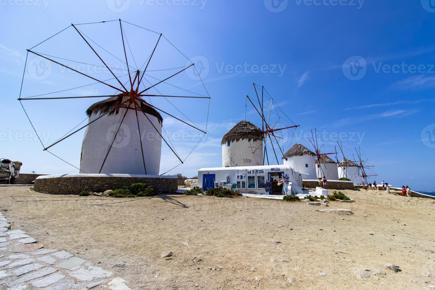 Traditional Greek windmills on Mykonos island under cloudy sky. Aerial view of iconic Mykonos windmills in Cyclades, Greece. photo