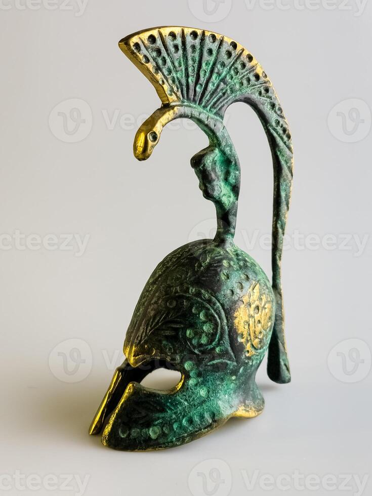 Bell in the form of an ancient Greek helmet made of bronze on a white background. photo