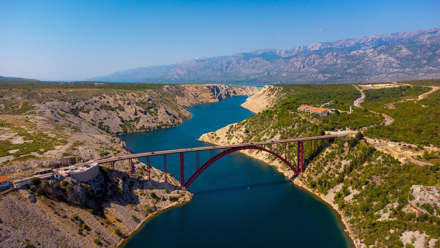 two bridges crossing a waterway, a fjord. Aerial view Maslenica bridge, arch bridge for car trip in Croatia. photo