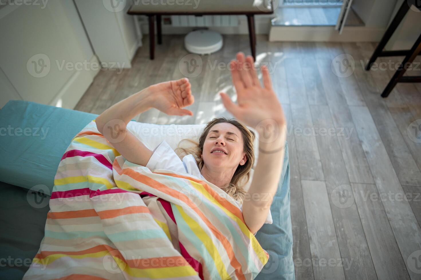Relaxed woman closes hand and want to stay in bed in morning. Early wake up, sleep interruption photo