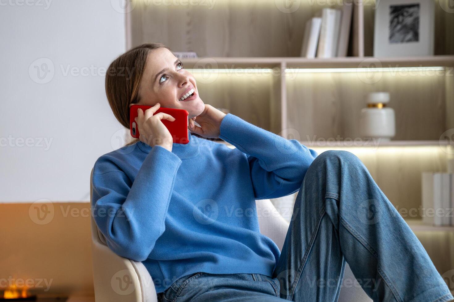 Happy woman smiling makes phone calls dreamily flirting with boyfriend at distant sitting at home. photo