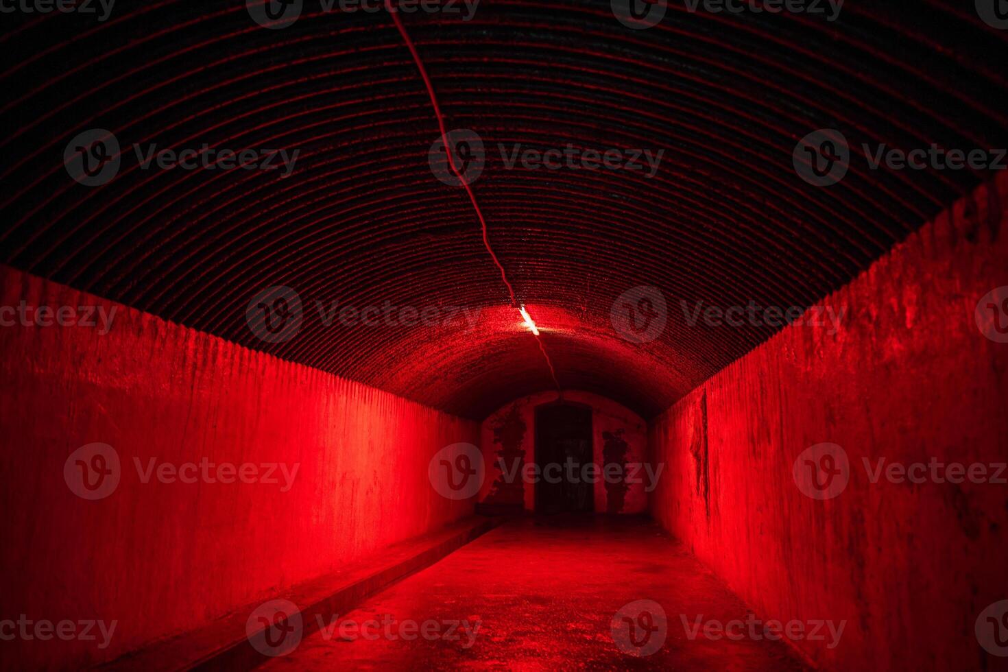 Red light corridor inside underground old bunker. Tunnel illuminated with bright red neon lights. photo