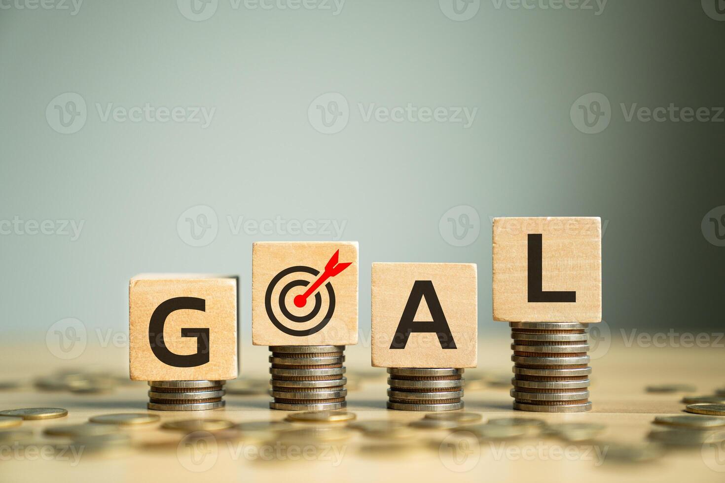 Wooden Block Letters Spelling GOAL Placed on Stacked Coins with Target Symbol, Representing Financial Goals, Ambition, and Strategic Planning for Success and Achievement photo