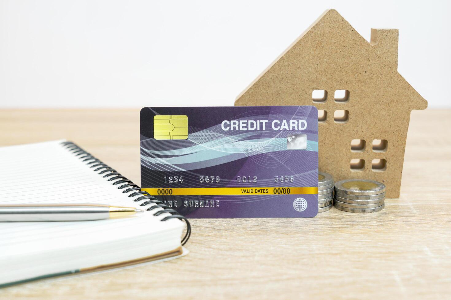 House model and credit card on table with note pad photo