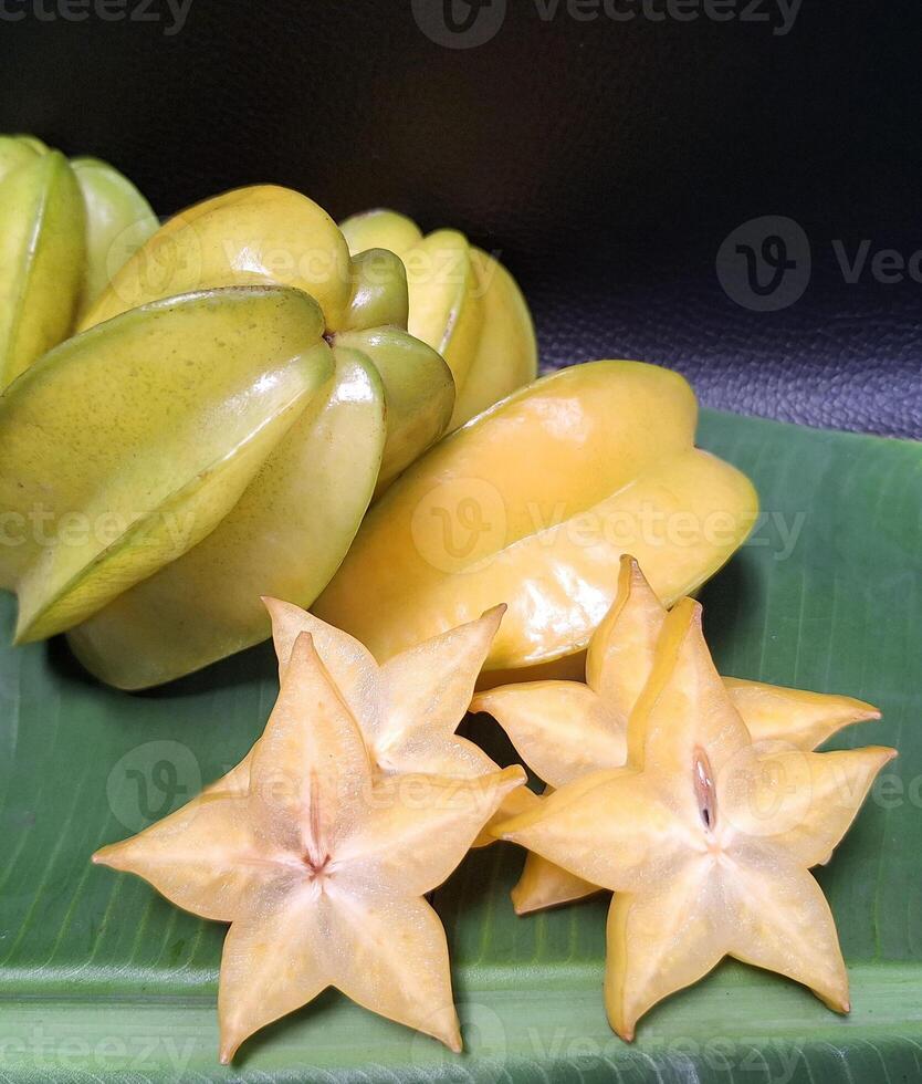 Multicolored overlapping star fruit background image on black background photo
