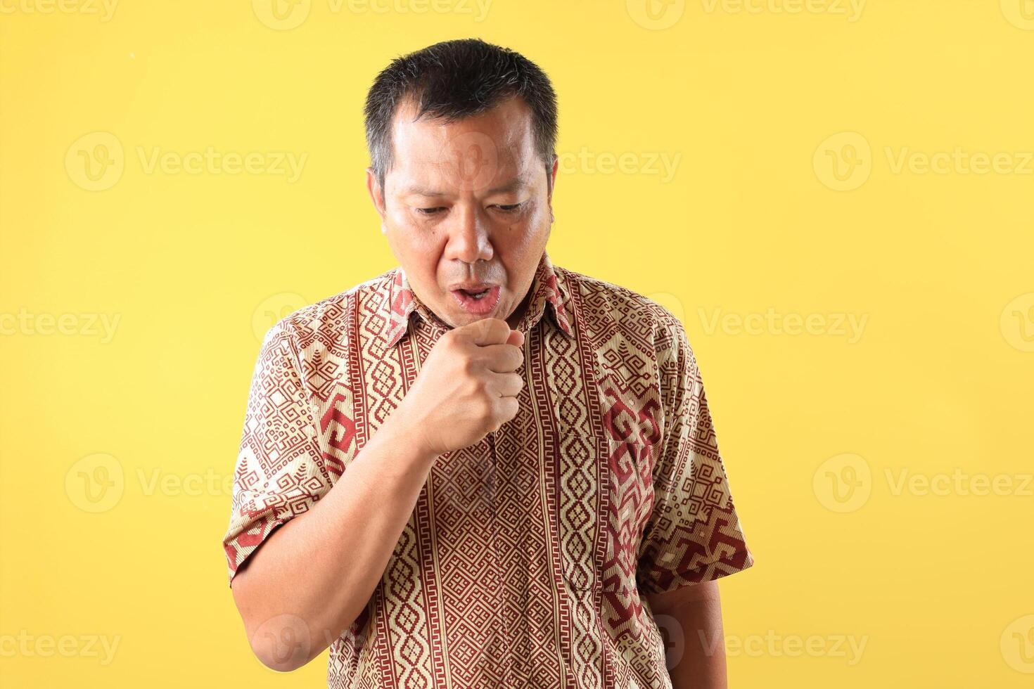 Portrait of Middle Age Asian Man Coughing Violently, Depicting Symptoms of Respiratory Illness photo