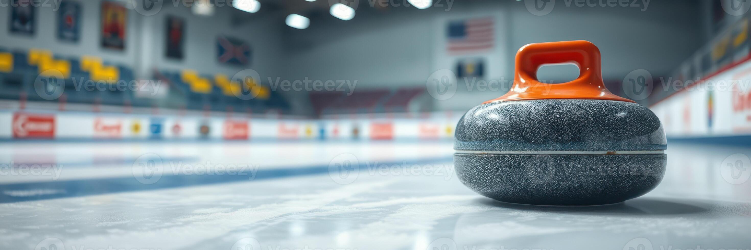 Curling stone positioned on the ice at an indoor curling rink during a competitive match photo