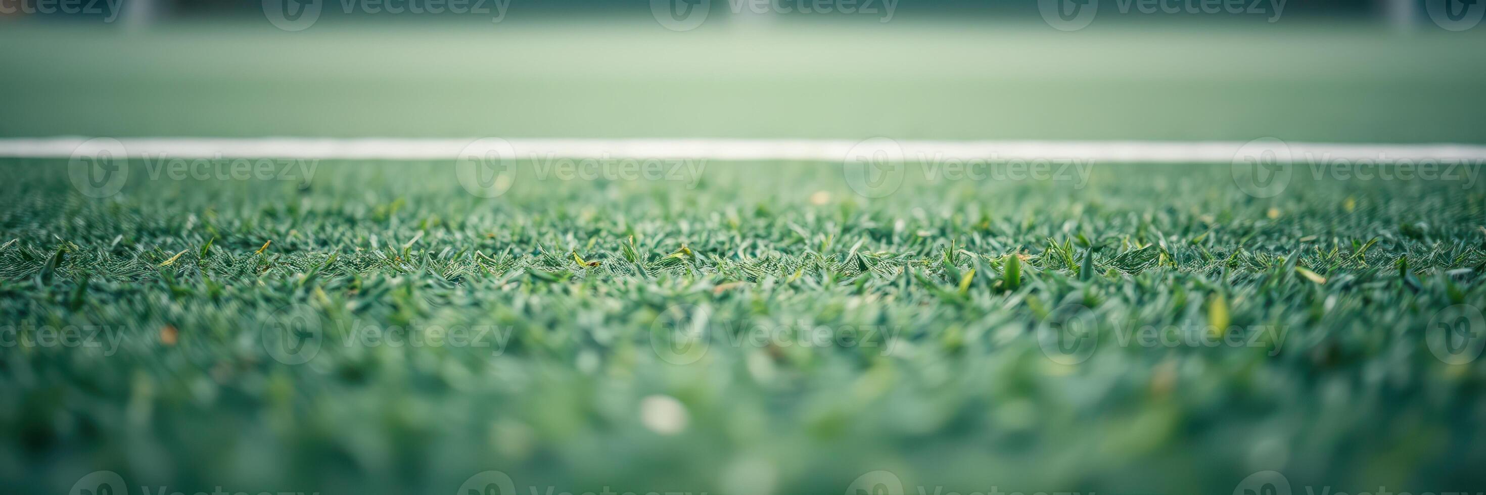 Lush green artificial turf close-up on a sports field under clear sky photo
