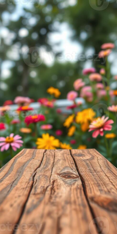 Colorful flowers bloom in a vibrant garden with a rustic wooden table in focus on a sunny day photo