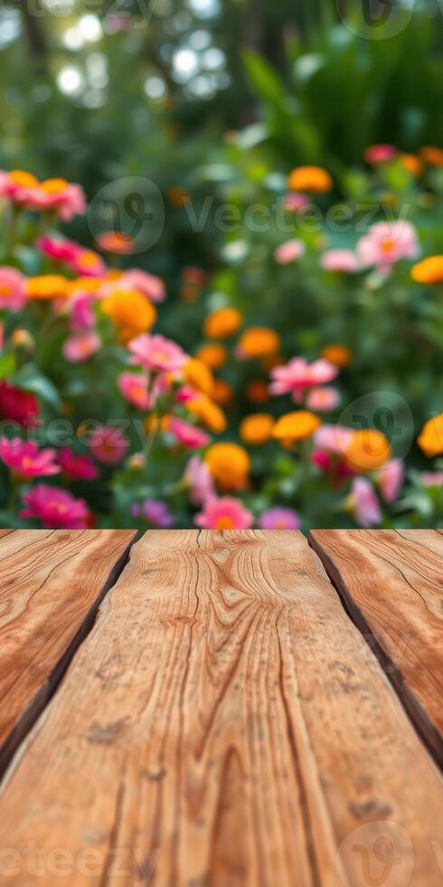 Colorful flowers bloom in a garden with a wooden table foreground during a sunny day in springtime photo