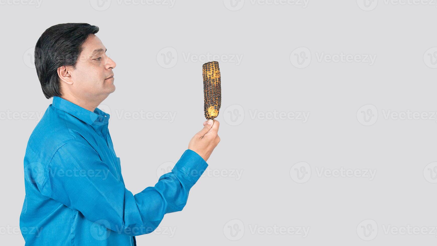 Close-up of a young boy holding a bowl of corn cob seeds in his right hand. copy space on right side photo