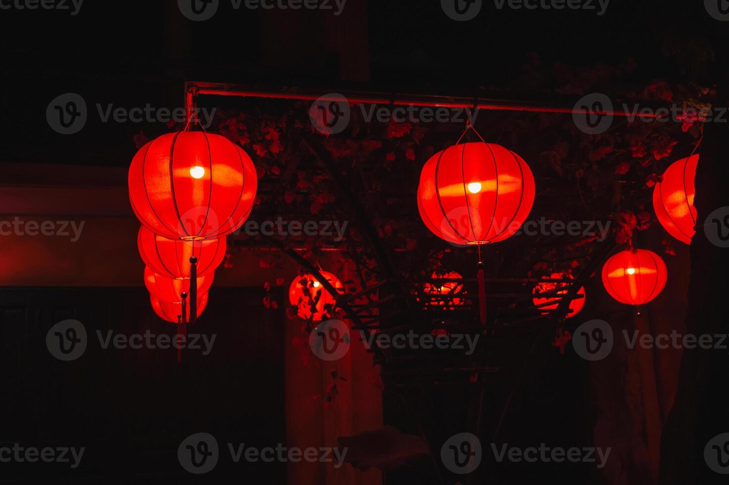 red traditional paper Chinese lanterns decorate facade of a building in Asia at night photo