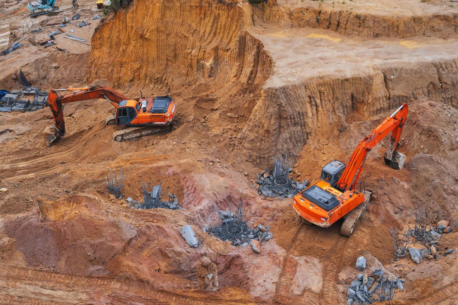 Excavators dig the ground in the foundation pit of building on a construction site. View from above photo