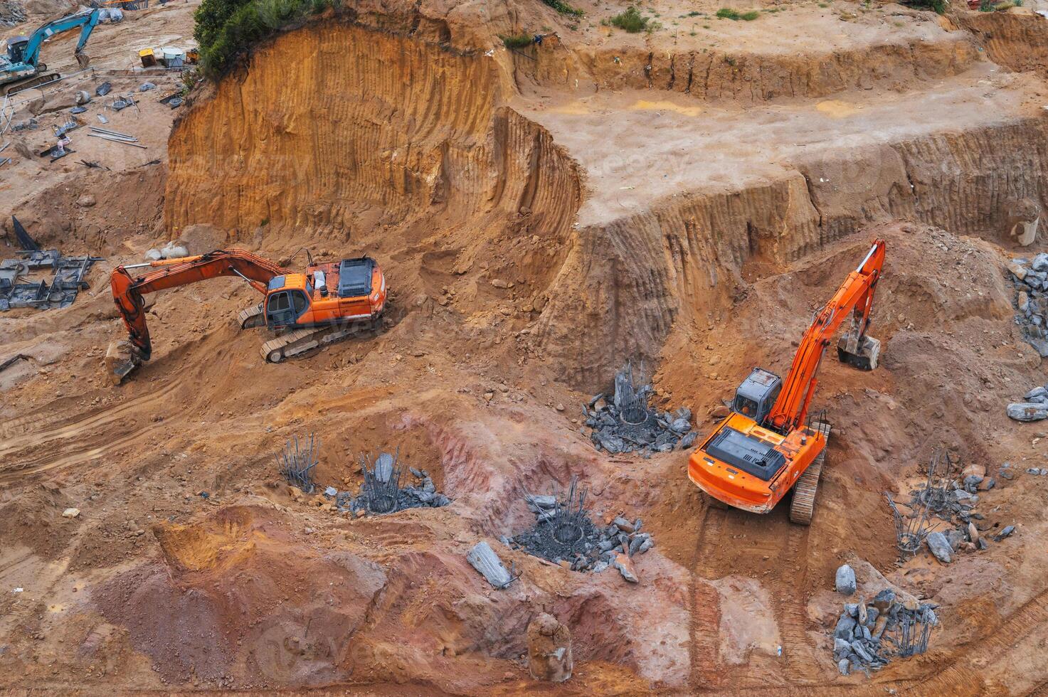 Excavators dig ground in foundation pit of building on a construction site. View from above photo