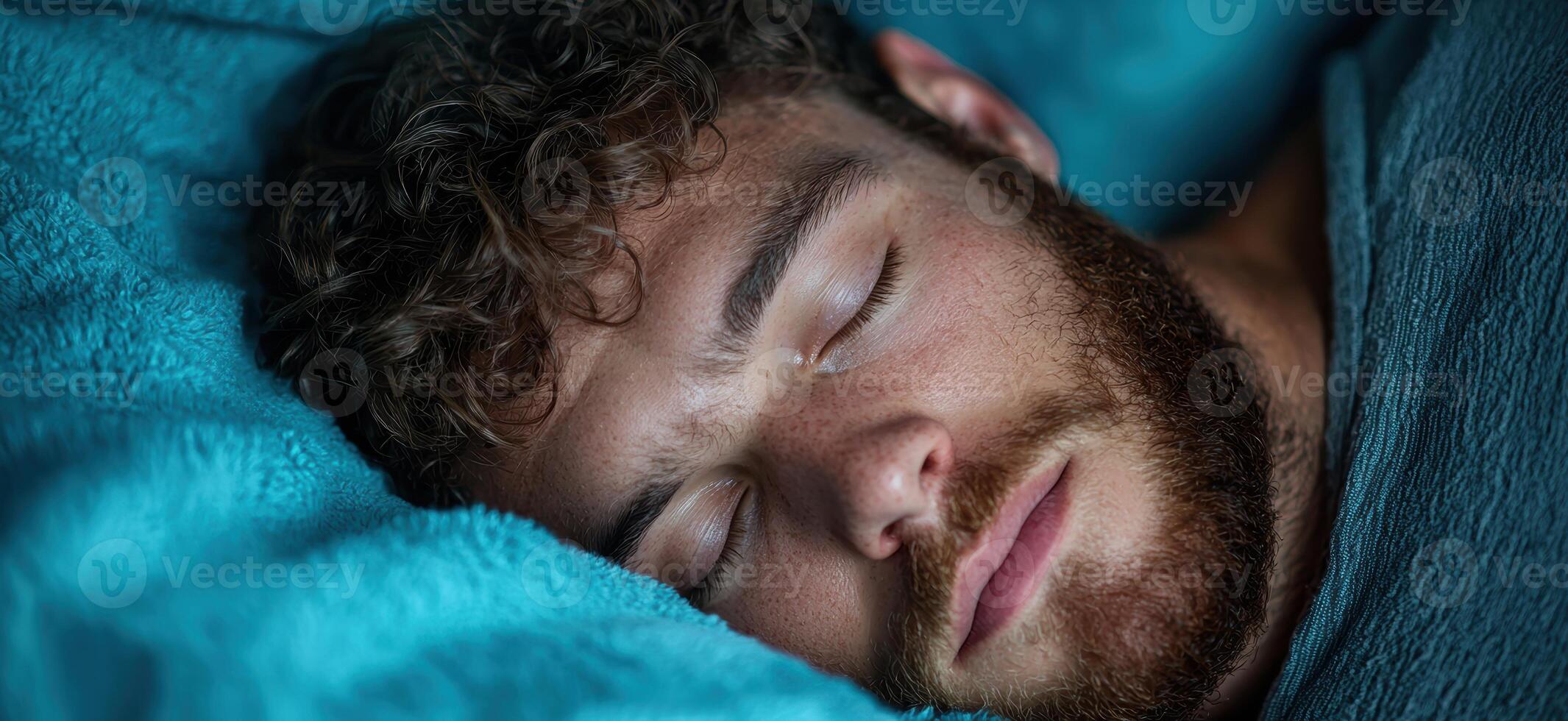 Man sleeping peacefully on a blue blanket photo
