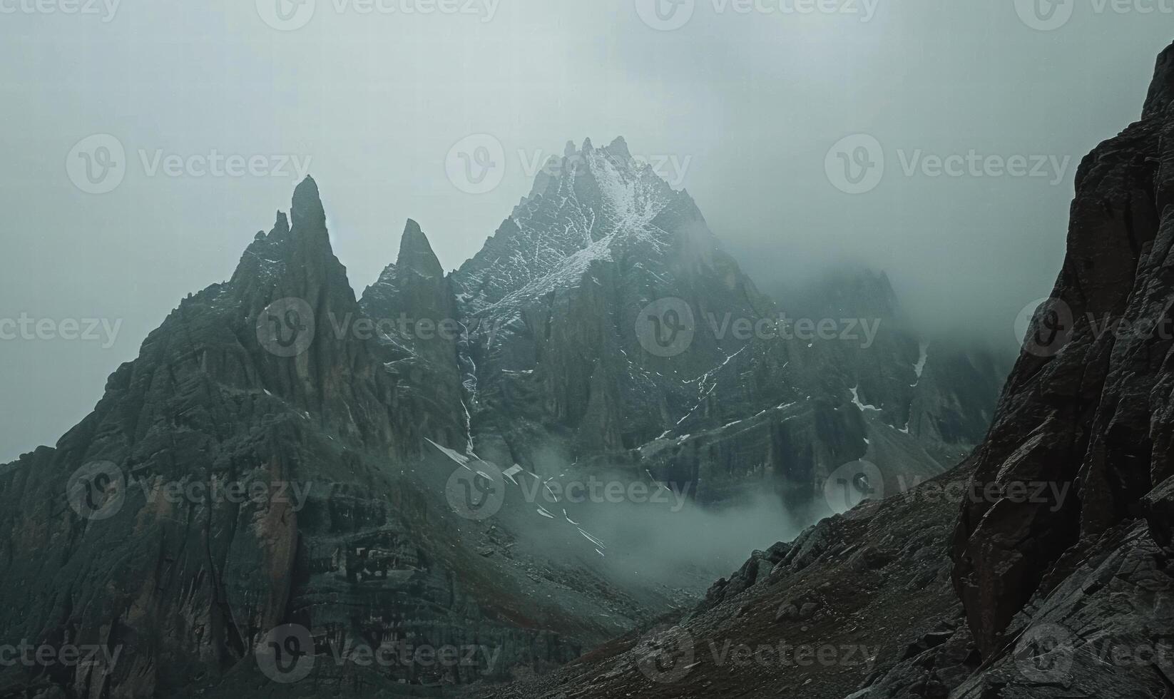 Majestic snow capped mountain peaks in the fog photo