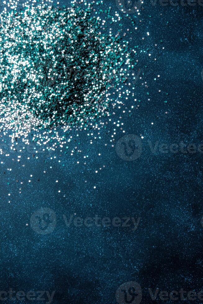Sparkling glitter on dark teal background photo