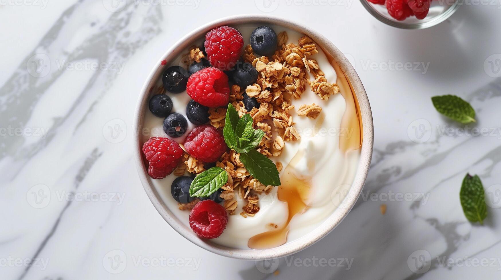 Greek yogurt layered with granola fresh berries honey and a sprig of mint served on a marble countertop, photography photo
