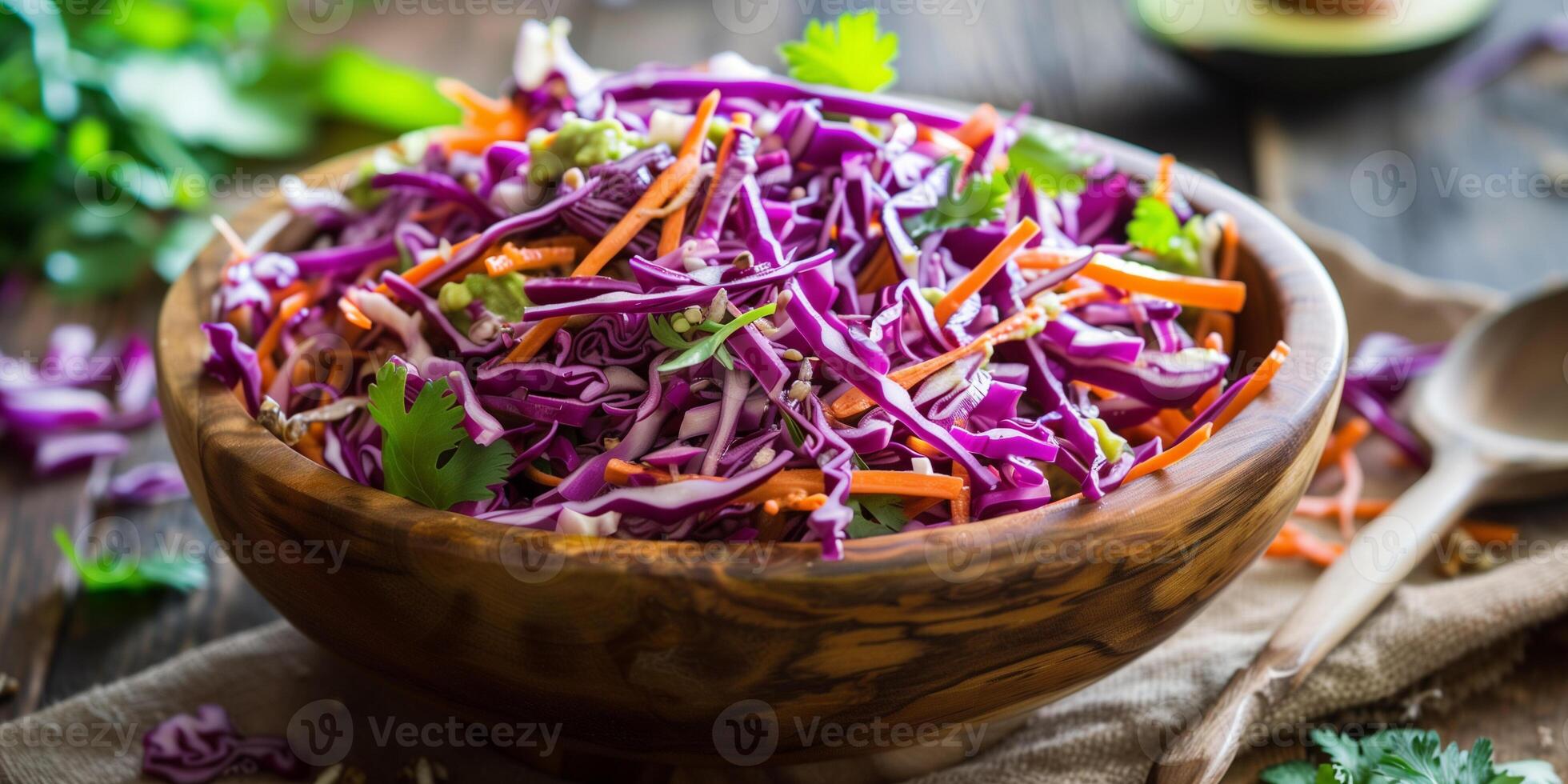 Colorful raw coleslaw with shredded red cabbage, carrots, and creamy avocado dressing in a rustic wooden bowl, photo