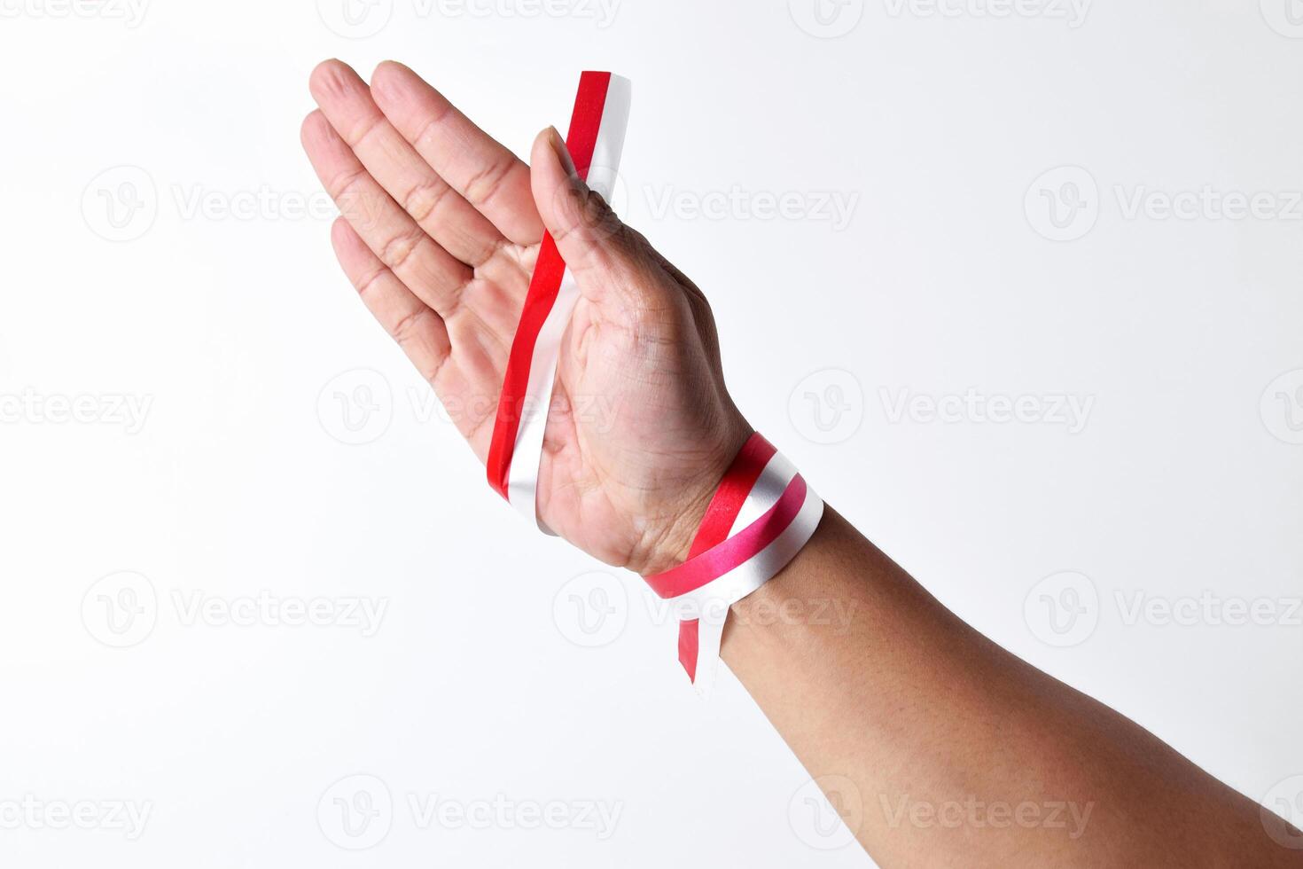 Hands spread with a red and white ribbon photo