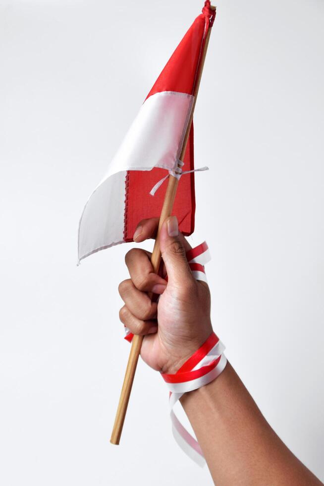 A man's hand raises the red and white flag of the Indonesian nation photo
