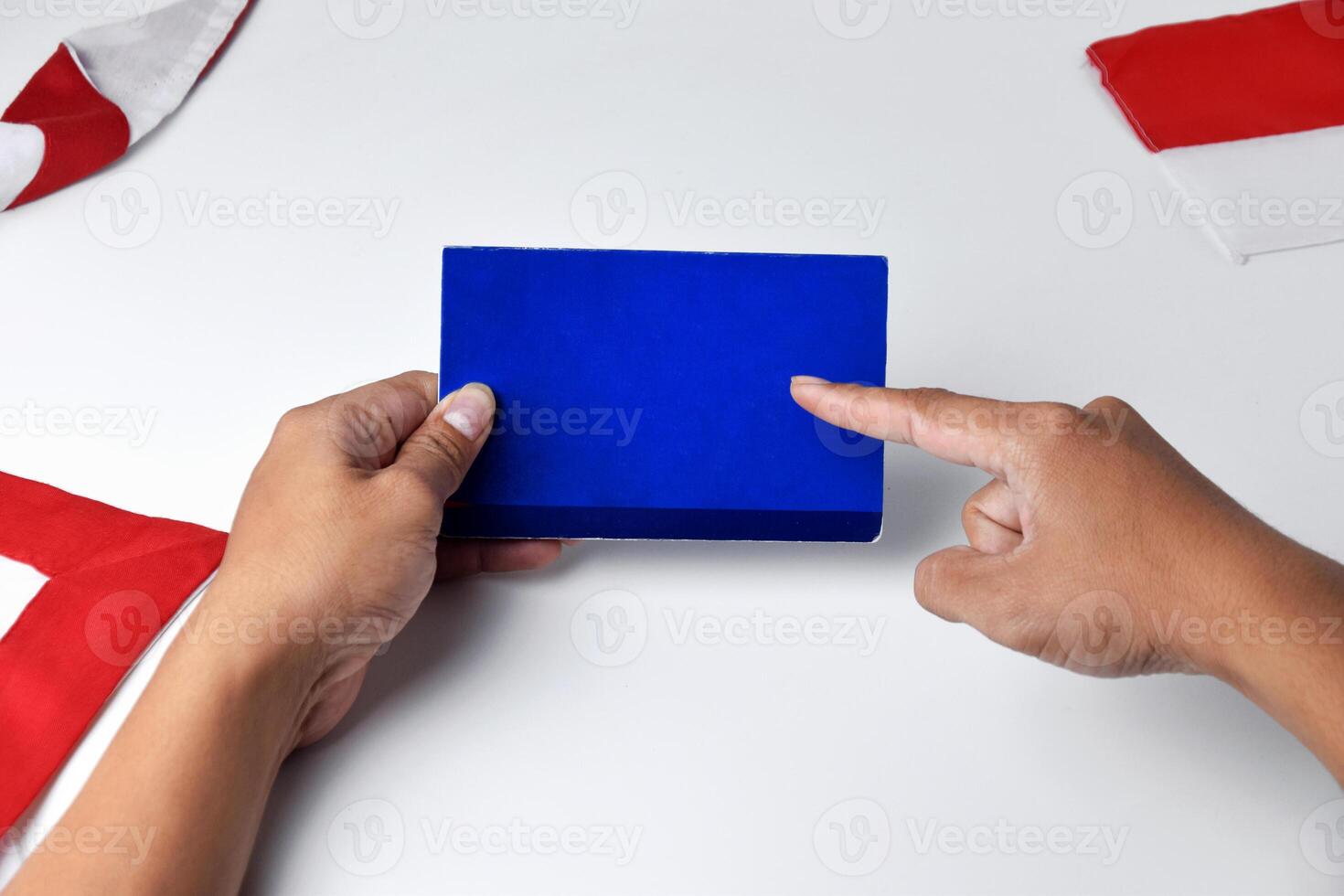 A person holds and shows a blue savings account book with white background photo
