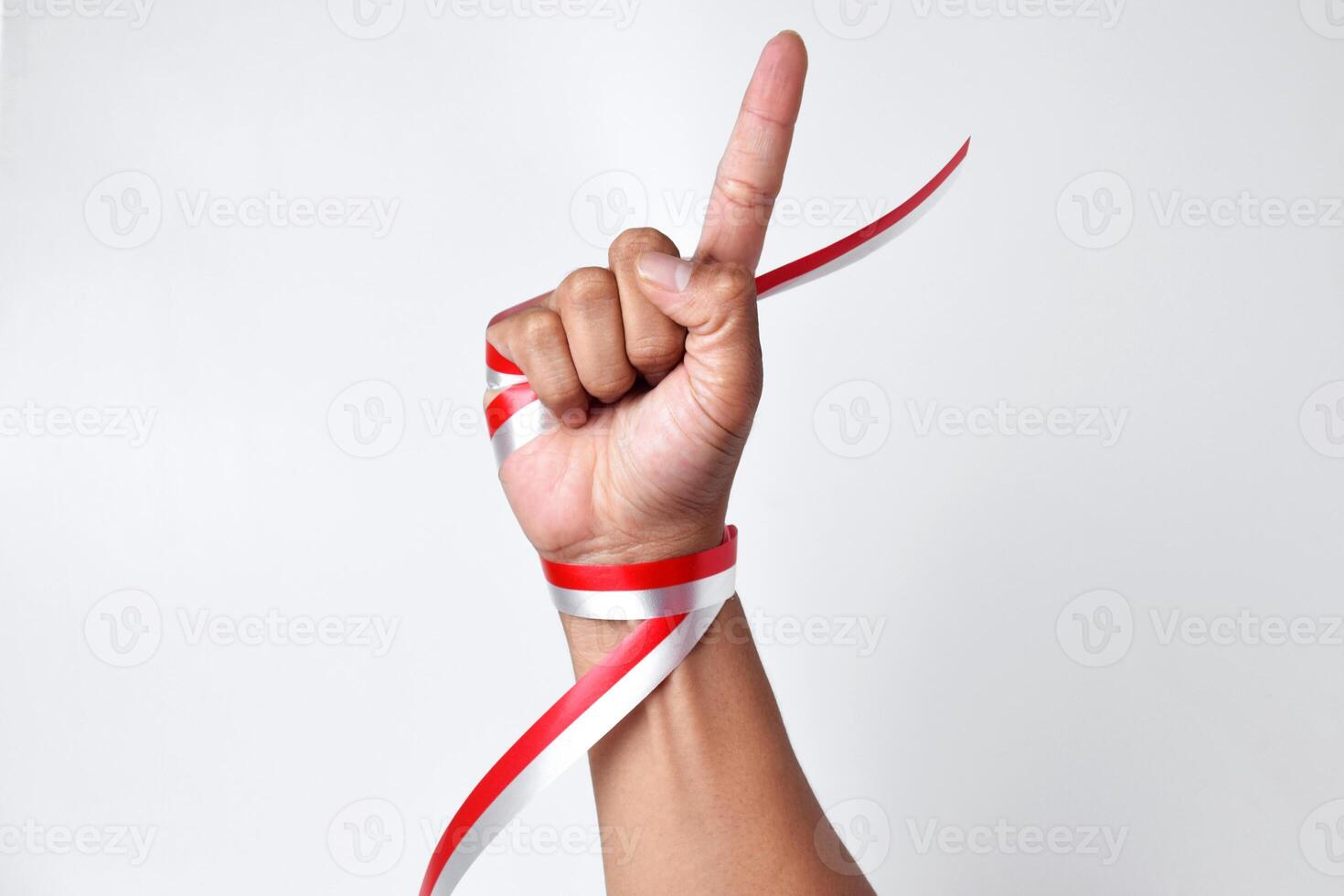 Human hand pointing one finger with red and white ribbon photo