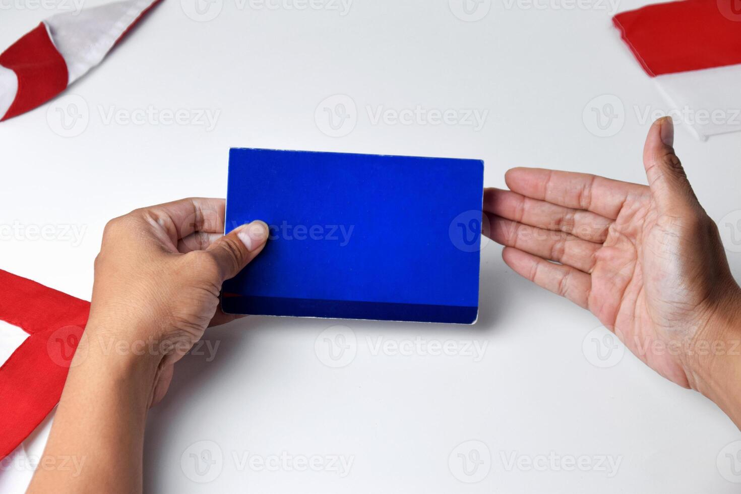 A person holds and shows a blue savings account book photo