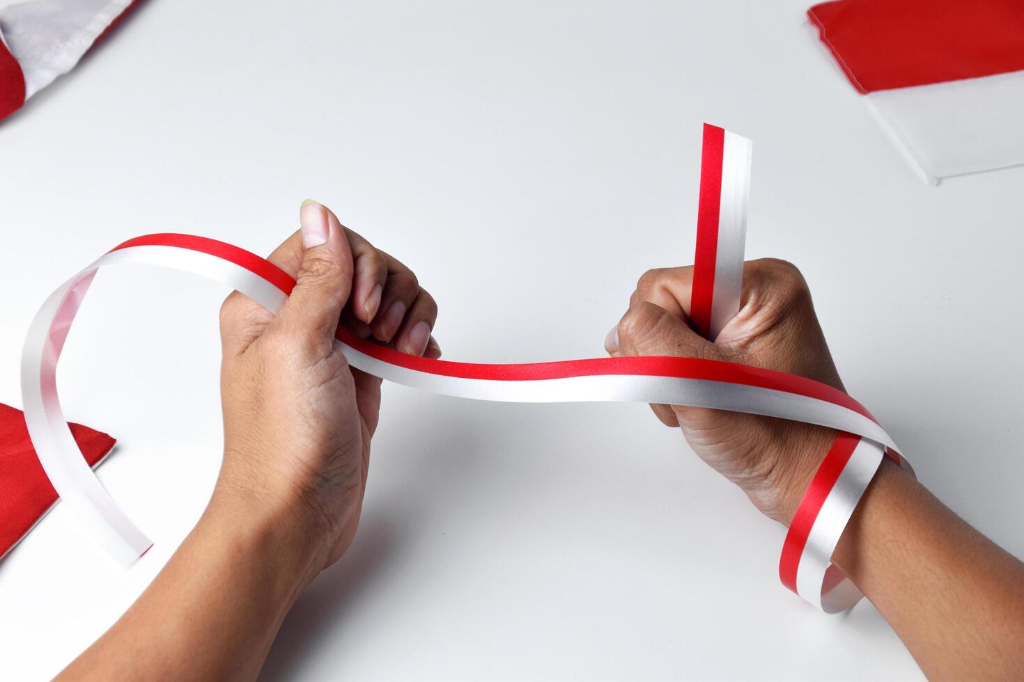 Hands clasped enthusiastically with a red and white ribbon wrapped photo