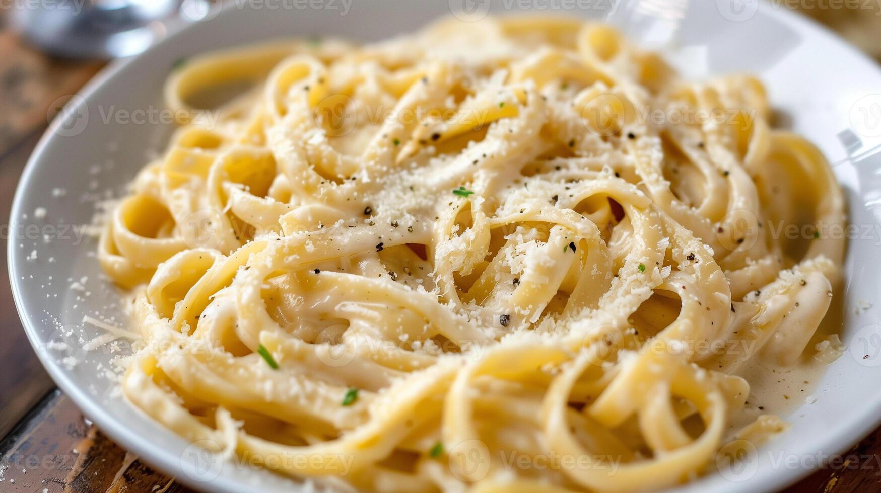 Plate of linguine pasta tossed in creamy Alfredo sauce with freshly grated Parmesan cheese, photo