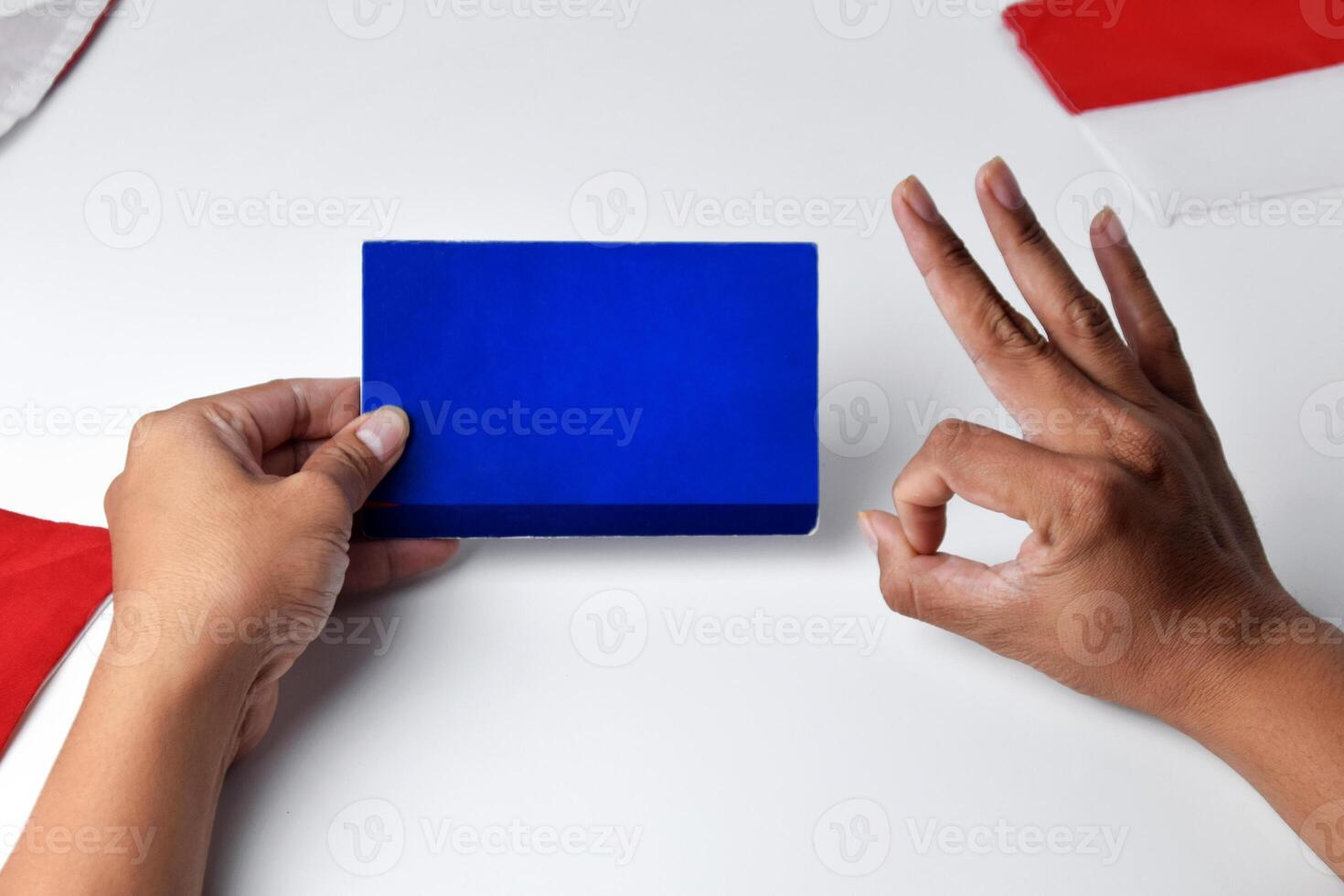 Hands holding and showing a blue savings account book with an okay gesture photo