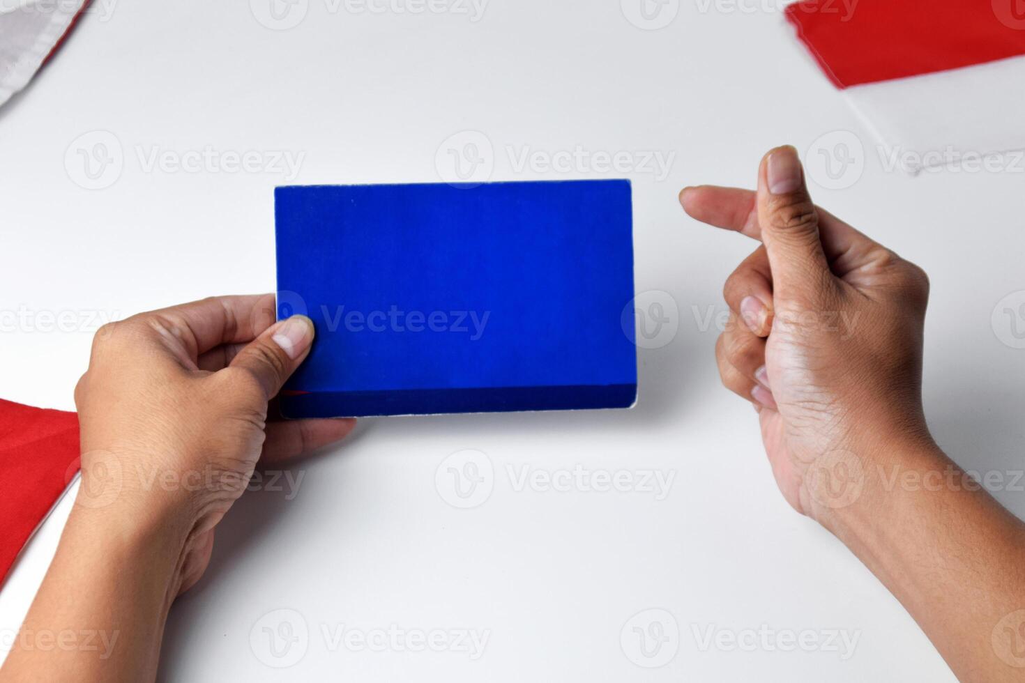 Hands holding and showing a blue savings account book with an okay gesture photo