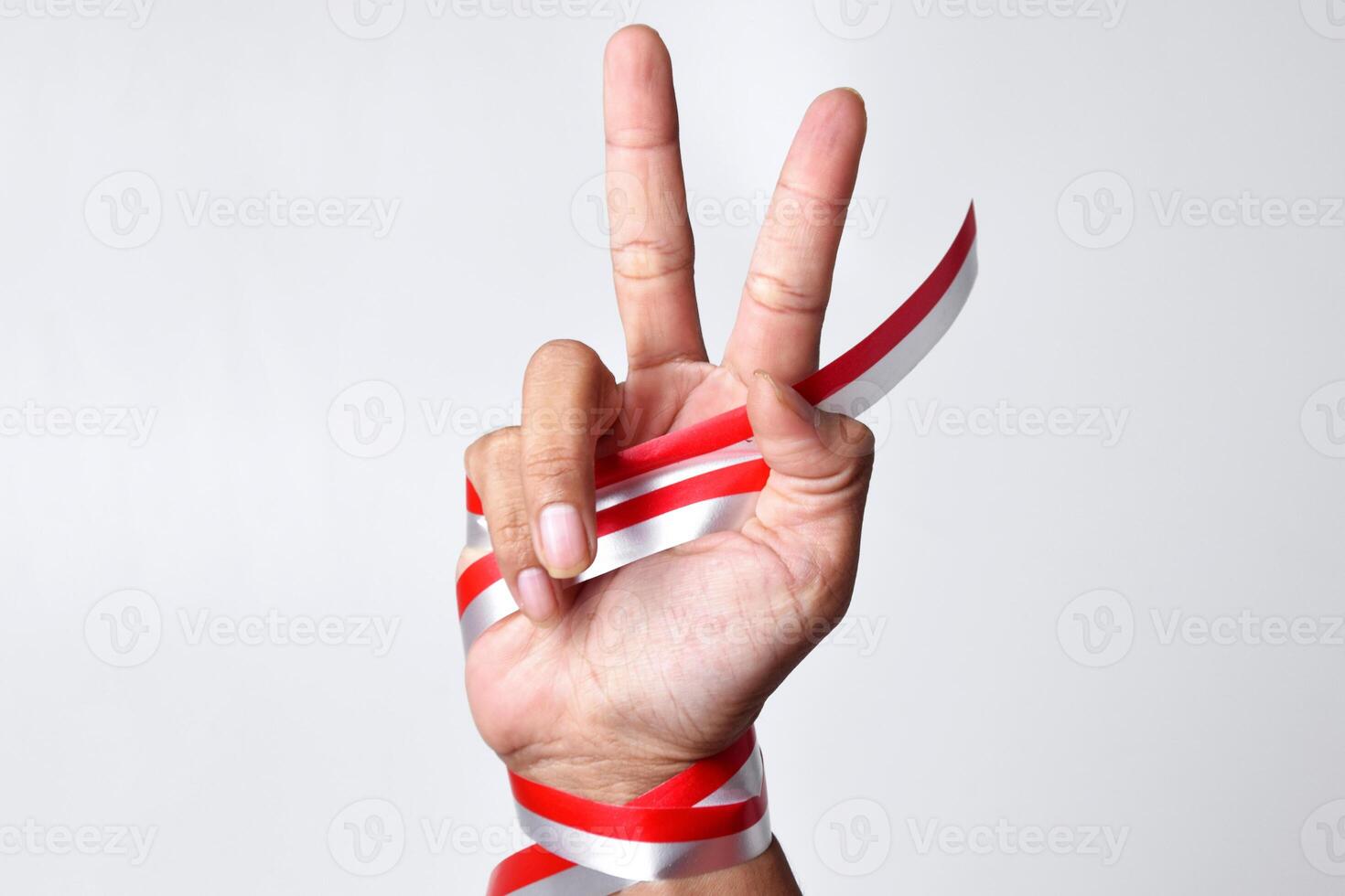 Two-finger greeting or peace with a red and white ribbon photo