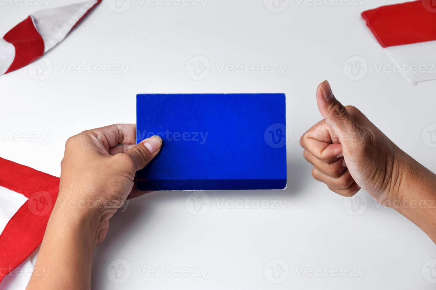 Hands holding and showing a blue savings account book with an okay gesture photo