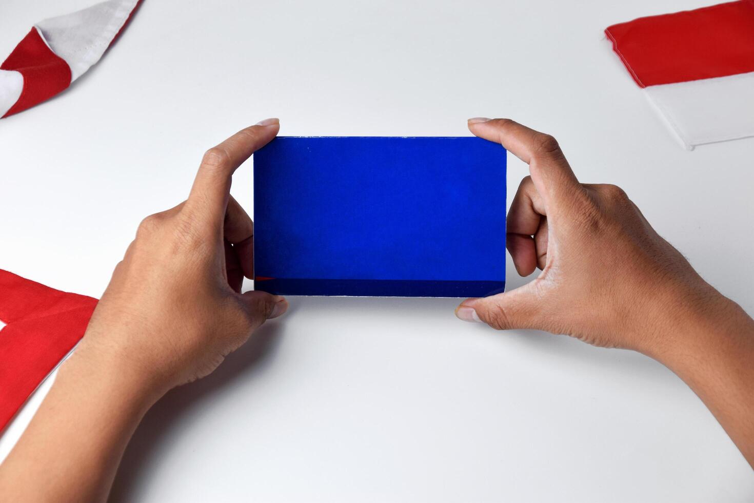 A person holds and shows a blue savings account book with white background photo