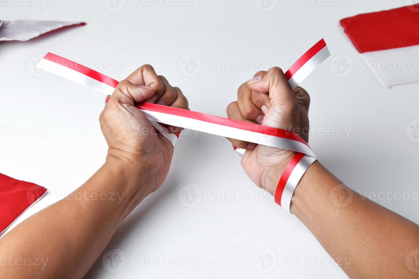 Hands clasped enthusiastically with a red and white ribbon wrapped photo