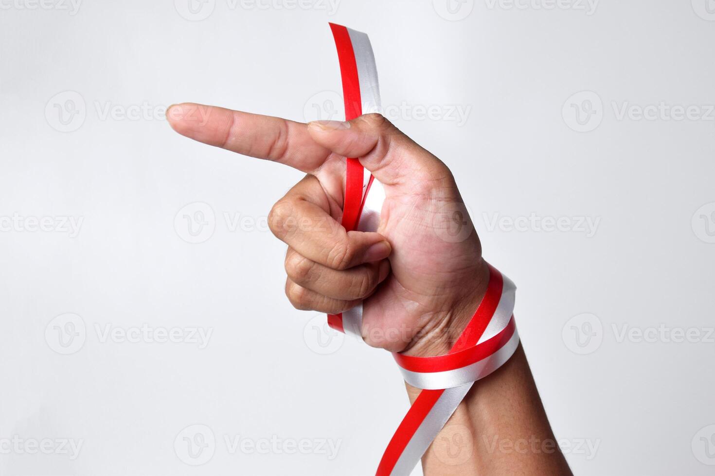 Human hand pointing with index finger with red and white ribbon photo