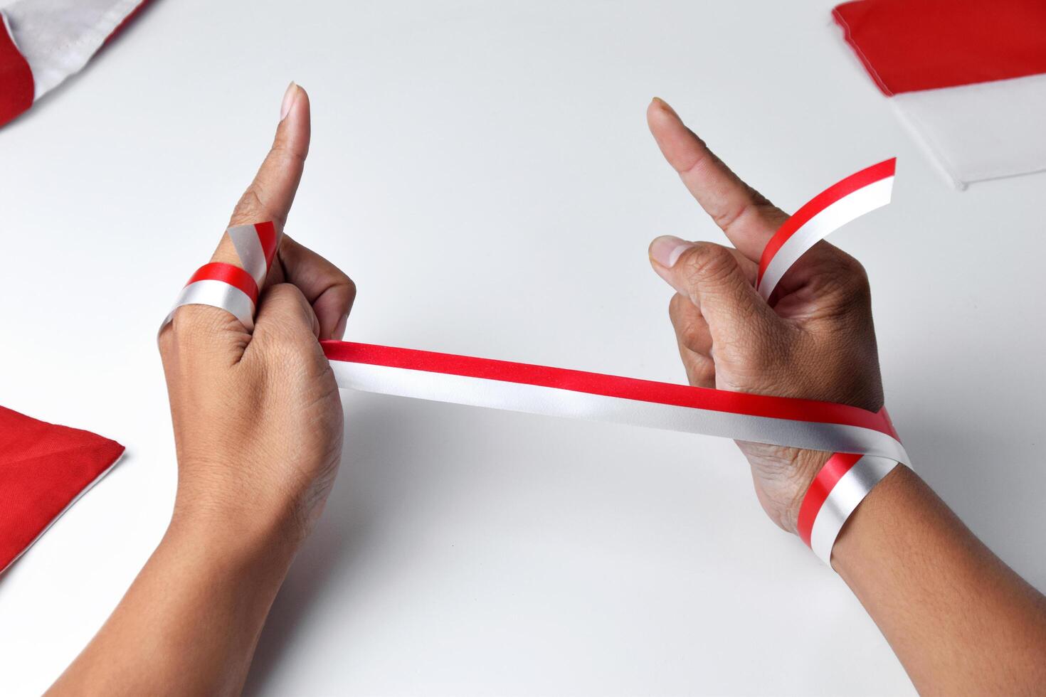 Hands clasped enthusiastically with a red and white ribbon wrapped photo