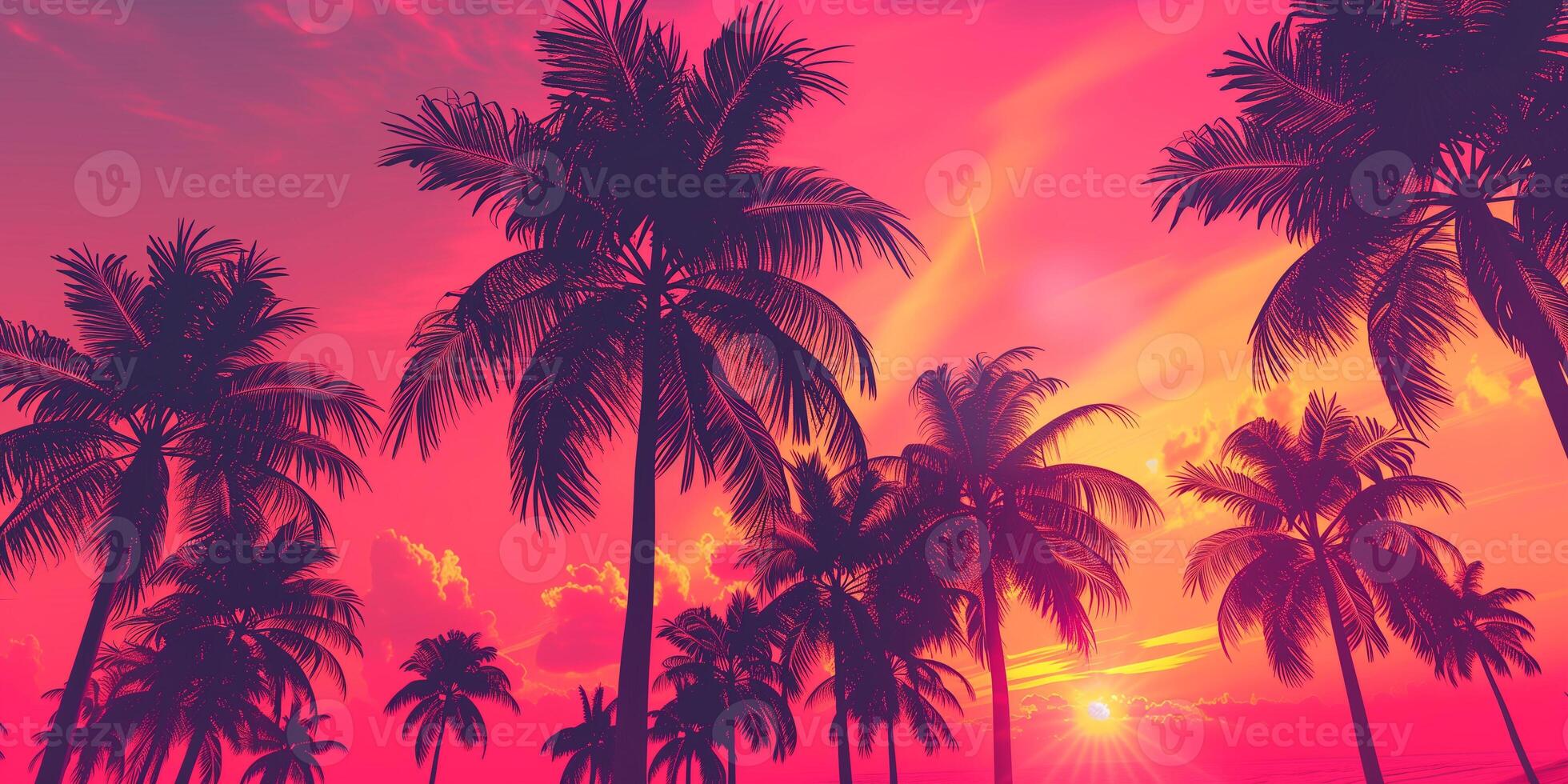 Pink and orange sky with silhouetted palm trees swaying in breeze, photo