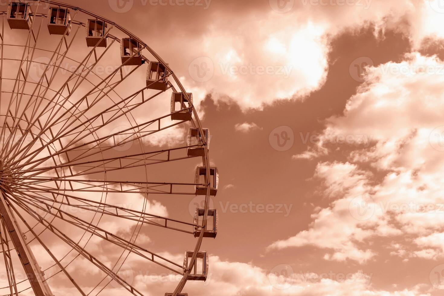 Big Ferris wheel and light Mocha brown sky with clouds photo