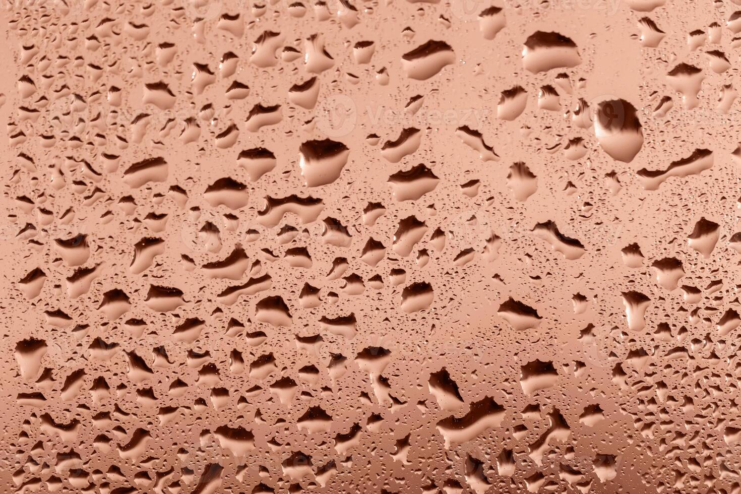 Drops on glass in sunset glow close up. Perfect Mocha brown background for your design and inspiration. Selective focus, defocus. Demonstrating color of 2025 year photo