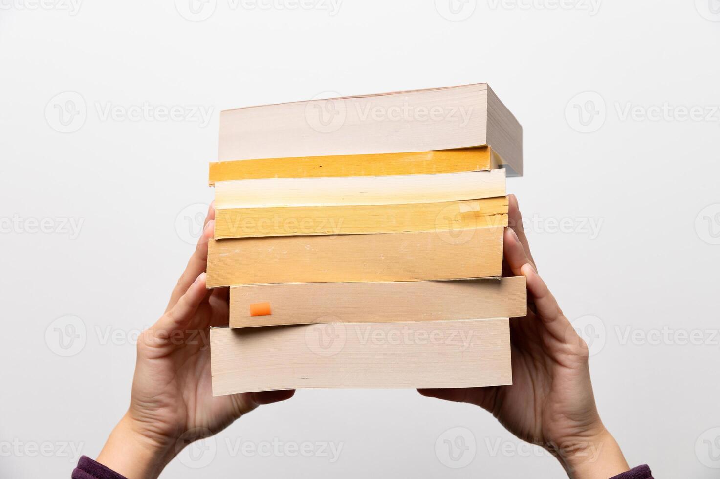 Stack of books in hand, Book Day, several books in hands on neutral white background. Home leisure. Self-isolation home, home schooling photo